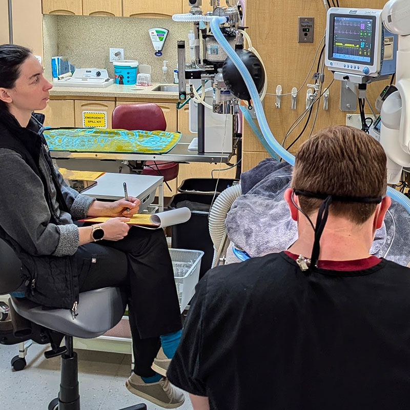 two individuals in a medical setting with equipment